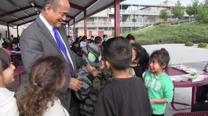 Godwin Higa helps a boy try on a Spiderman hoodie. 