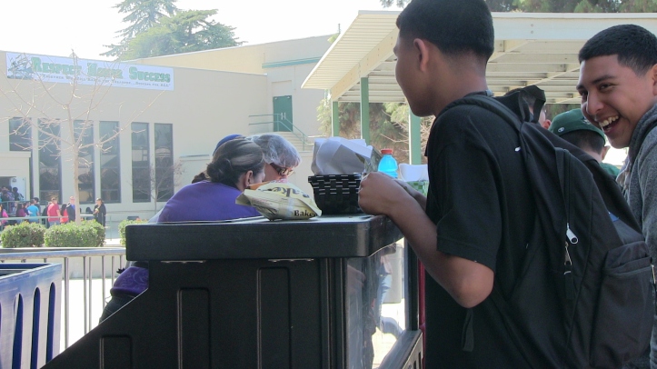 Students line up to buy lunch in Reedley High School plaza. 