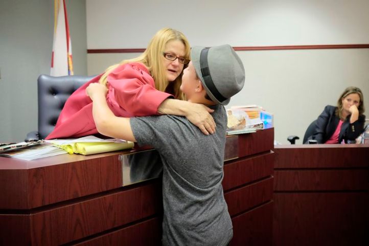 Judge Lynn Tepper hugs Taylor, 11, at his final adoption hearing. Before finding his permanent home, he'd been returned by three families since being removed from his biological mother when he was three years old. 