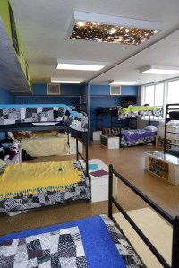 Through the process of becoming trauma-informed, white walls were painted colors chosen by the youth, a curtain was installed to create more privacy, and lighting was dimmed to create a more comfortable atmosphere at the San Diego Youth Services Storefront Shelter.